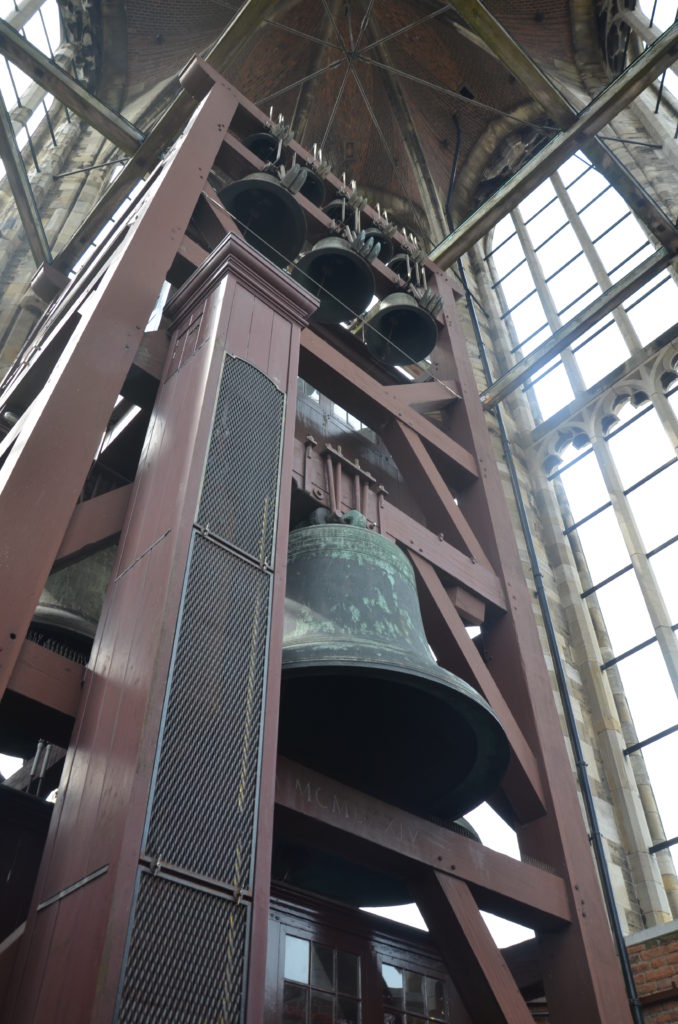 A large bell, hanging on beams in the inside of the tower. Utrecht with kids.