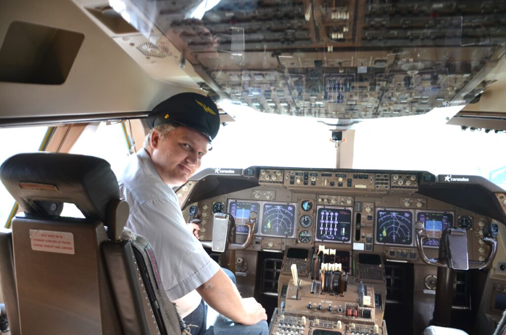 Paul the pilot! Paul sitting in the cockpit of the 747-400 with a pilot hat on