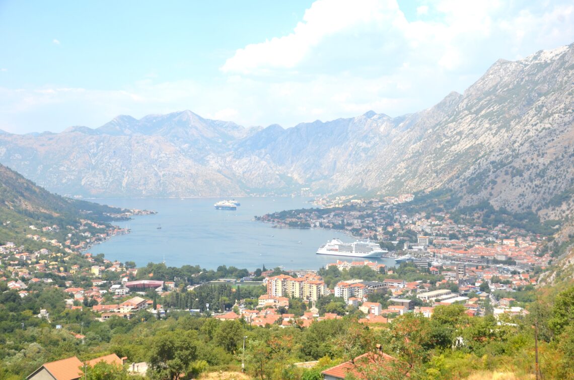 Bay of Kotor, as seen from inside the gorge, from higher up and farther away. An overview of Kotor and the bay with cruise ships in the water, mountains on all sides