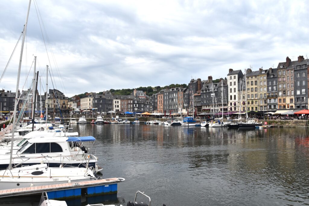 The harbor of Honfleur, old houses on the other side of the canal. Boats docking the sides on both sides of the canal