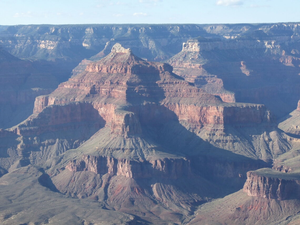 The Grand Canyon. As seen from a viewpoint on the south rim. High peaks in different colors and below the Colorado river in the valley.